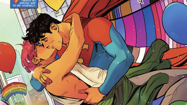 Jay Nakamura and Jon Kent/Superman kiss in DC Pride 2022. Jon is wearing his Superman costume with a cape lined with the colors of many LGBTQ Pride flags. From DC Pride 2022. 