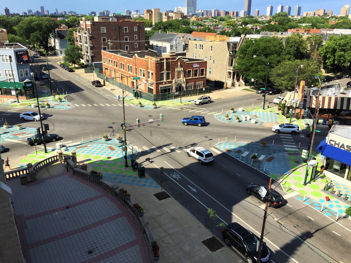 A busy intersection where several streets meet at different angles has been painted on each corner with polka-dots to create pedestrian plazas.