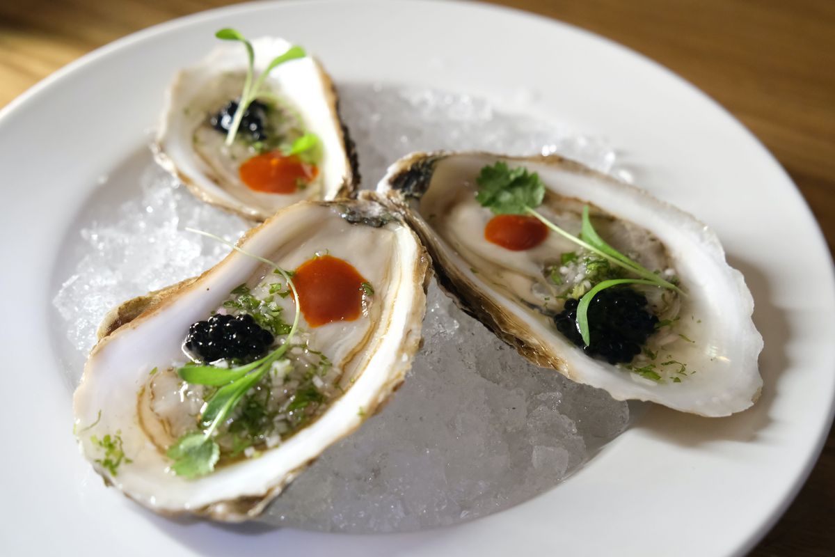 three oysters on plate with toppings.