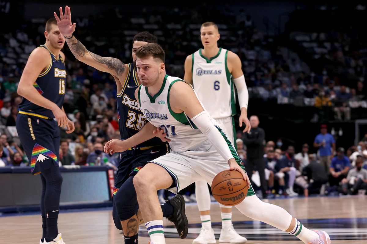 Luka Doncic #77 of the Dallas Mavericks drives to the basket against Austin Rivers #25 of the Denver Nuggets in the first quarter at American Airlines Center on November 15, 2021 in Dallas, Texas.