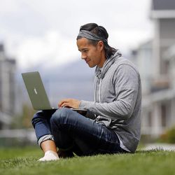 Garrett Gee works on his laptop outside his home in Vineyard, Utah County, Wednesday, May 20, 2015.