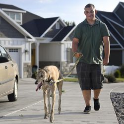 Gage Bowls walks his aunt's dog, Andy, a Greyhound, in the Bowls' neighborhood in Spanish Fork on Aug. 16, 2017. Having been born with cerebral palsy, Gage is trying to develop independence with his own dog-walking business.