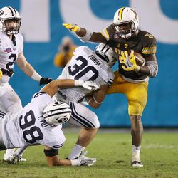 The Brigham Young Cougars defense tackle Wyoming Cowboys running back Brian Hill (5) during the Poinsettia Bowl in San Diego on Wednesday, Dec. 21, 2016. BYU won 24-21.