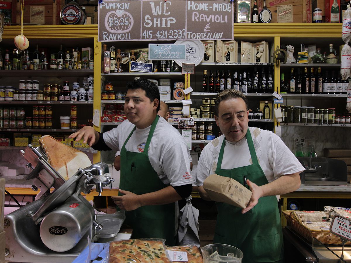 Juan Carnejo (left) and Vince Balistreri serve customers during the busy lunch hour at Molinari Delicatessen in the North Beach neighborhood of San Francisco, Calif. on Thursday, Dec. 12, 2013.