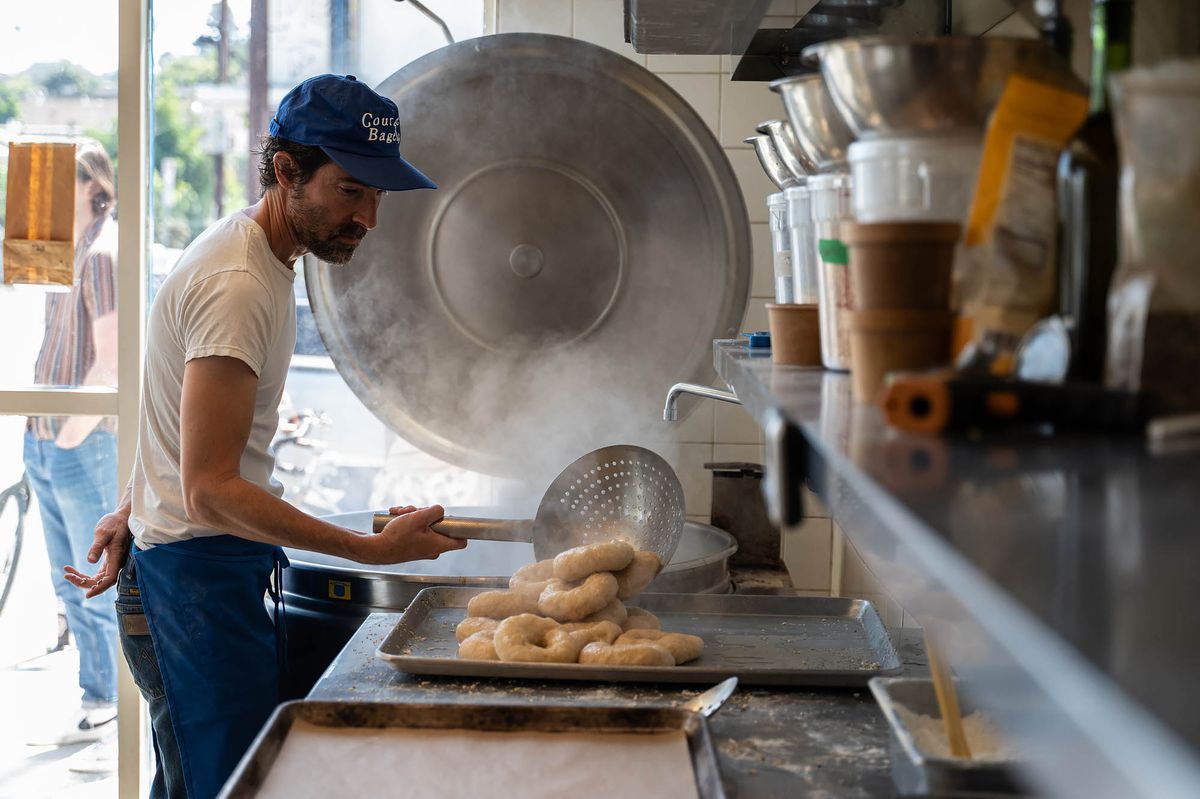 Moss removing freshly boiled bagels from the kettle at Courage Bagels.  