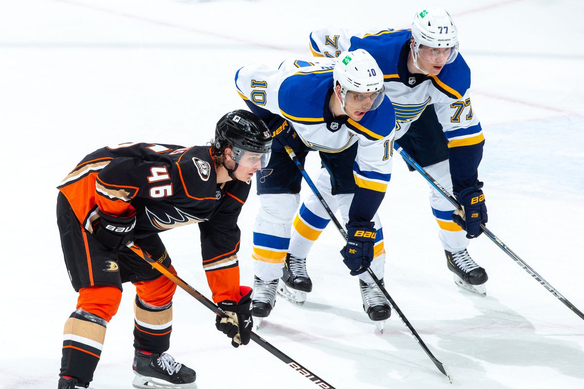 Brayden Schenn #10 and Niko Mikkola #77 of the St. Louis Blues and Trevor Zegras #46 of the Anaheim Ducks wait for a face-off during the third period of the game at Honda Center on March 3, 2021 in Anaheim, California.