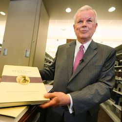 LDS Church Historian and Recorder Elder Steven E. Snow, shows a few of the pages of the new volume as the LDS Church, in cooperation with the Community of Christ announces the release of the printers manuscript of the the Book of Mormon, during a press conference Tuesday, Aug. 4, 2015, at the LDS Church's History library in Salt Lake City.