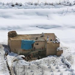 An Afghan family is seen at their home after an avalanche in the Paryan district of Panjshir province, north of Kabul, Afghanistan, Friday, Feb. 27, 2015. The death toll from severe weather that caused avalanches and flooding across much of Afghanistan has jumped to more than 200 people, and the number is expected to climb with cold weather and difficult conditions hampering rescue efforts, relief workers and U.N. officials said Friday. 