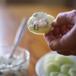 The three-ingredient healthy holiday dip is served on a sliced cucumber.