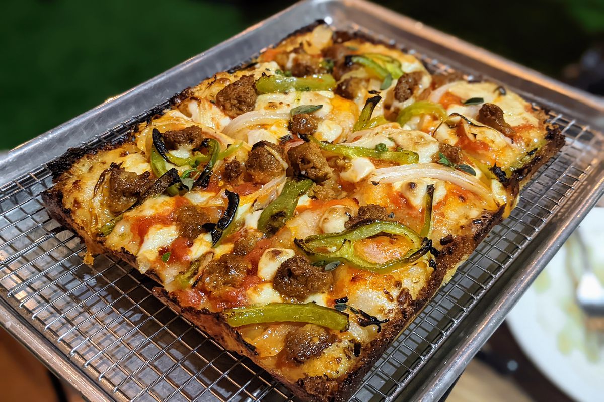 A Detroit-style pizza from Margo’s in Santa Monica, with a gluten-free crust, on a metal tray.
