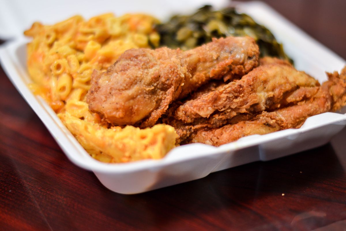 Fried chicken, mac and cheese, and collard greens in a styrofoam container