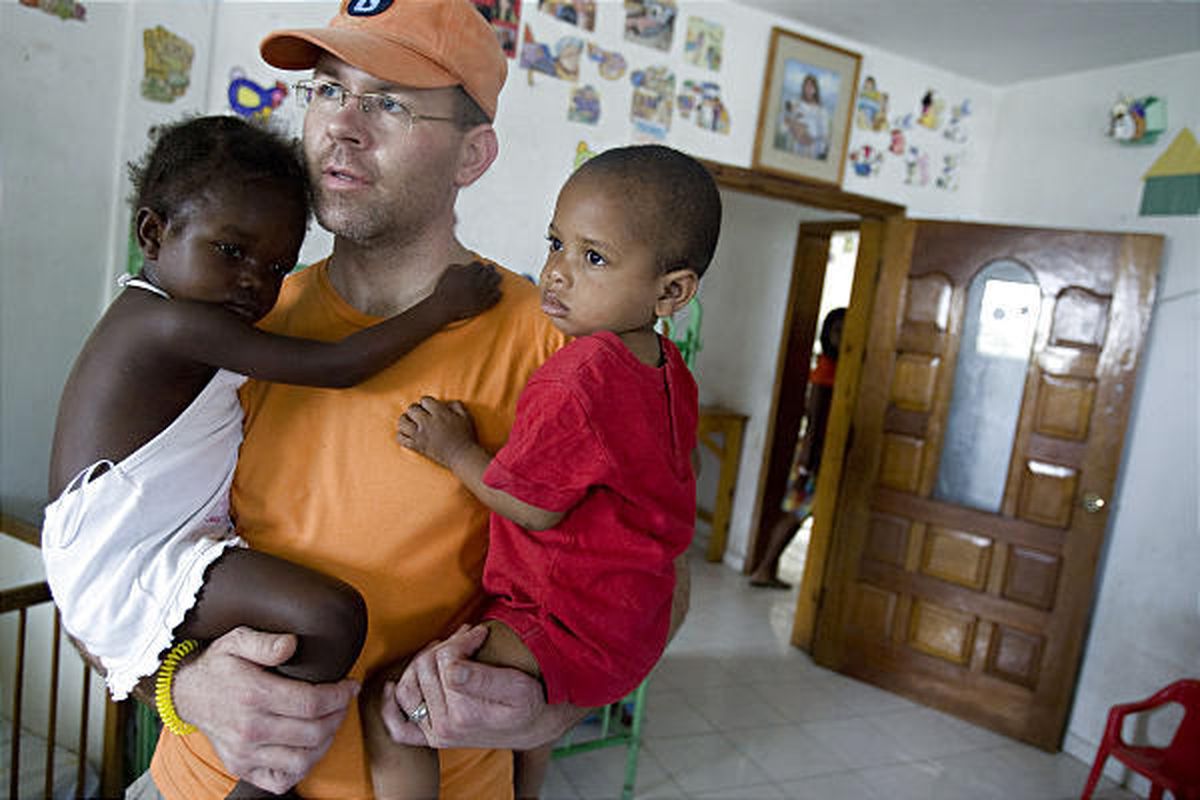Scott Gordon holds his daughter Averie, left, and Jean Peter at the Foyer de Sion orphanage in Port-au-Prince, Haiti, on Jan. 26. 