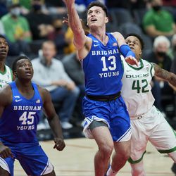 BYU guard Alex Barcello (13) shoots in front of Oregon guard Jacob Young during the second half of an NCAA college basketball game in Portland, Ore., Tuesday, Nov. 16, 2021.