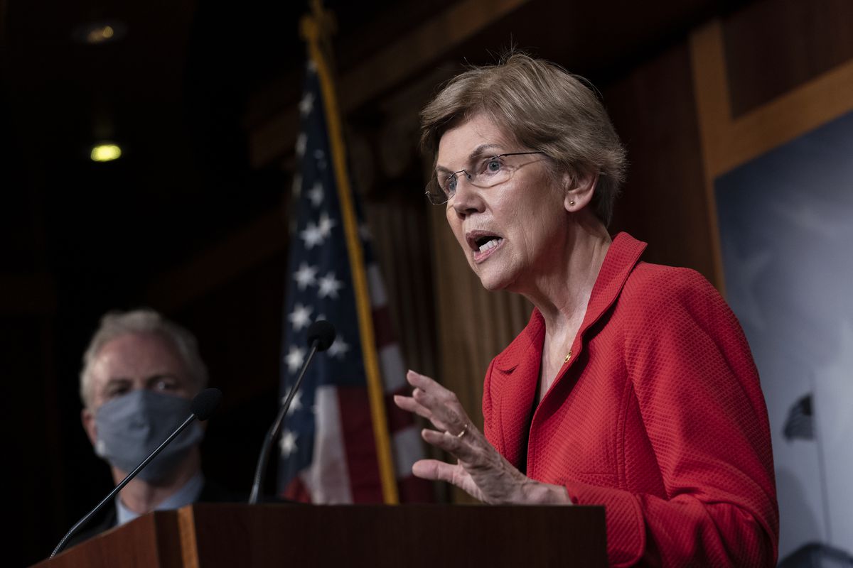 Sen. Elizabeth Warren speaks at a podium, backed by an American flag.