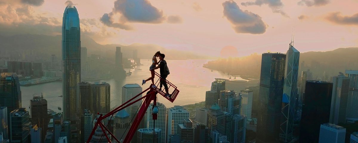 Angela Nikolau and Ivan Beerkus kissing on a crane high above a city 