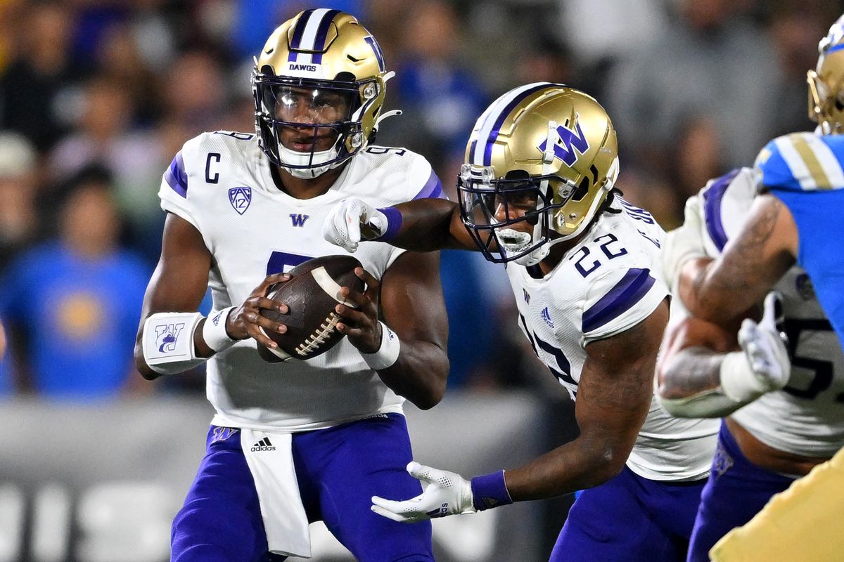 Washington Huskies quarterback Michael Penix Jr. hands off to running back Cameron Davis in the first half against the UCLA Bruins at the Rose Bowl.