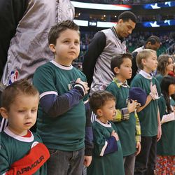 Jaxen Frisk, third from left, joins children living with chronic and debilitating rare diseases or their surviving siblings, who will carry a portrait in memory of a loved one, as they stand with members of the Utah Jazz and the San Antonio Spurs during the national anthem prior to the game. They are wearing lapel pins and wristbands from the National Organization for Rare Disorders Monday, Feb. 23, 2015, in Salt Lake City.  

