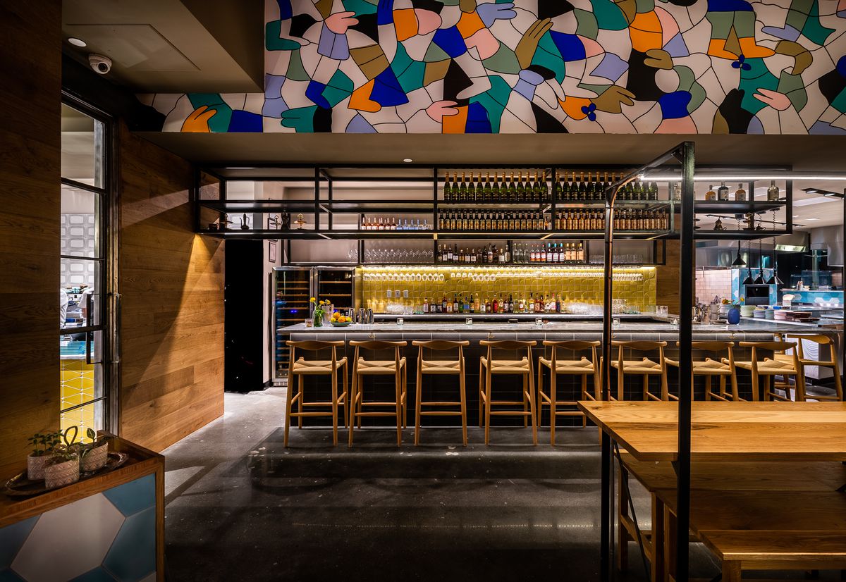The bar at Albi sits underneath one end of a colorful 50-foot mural