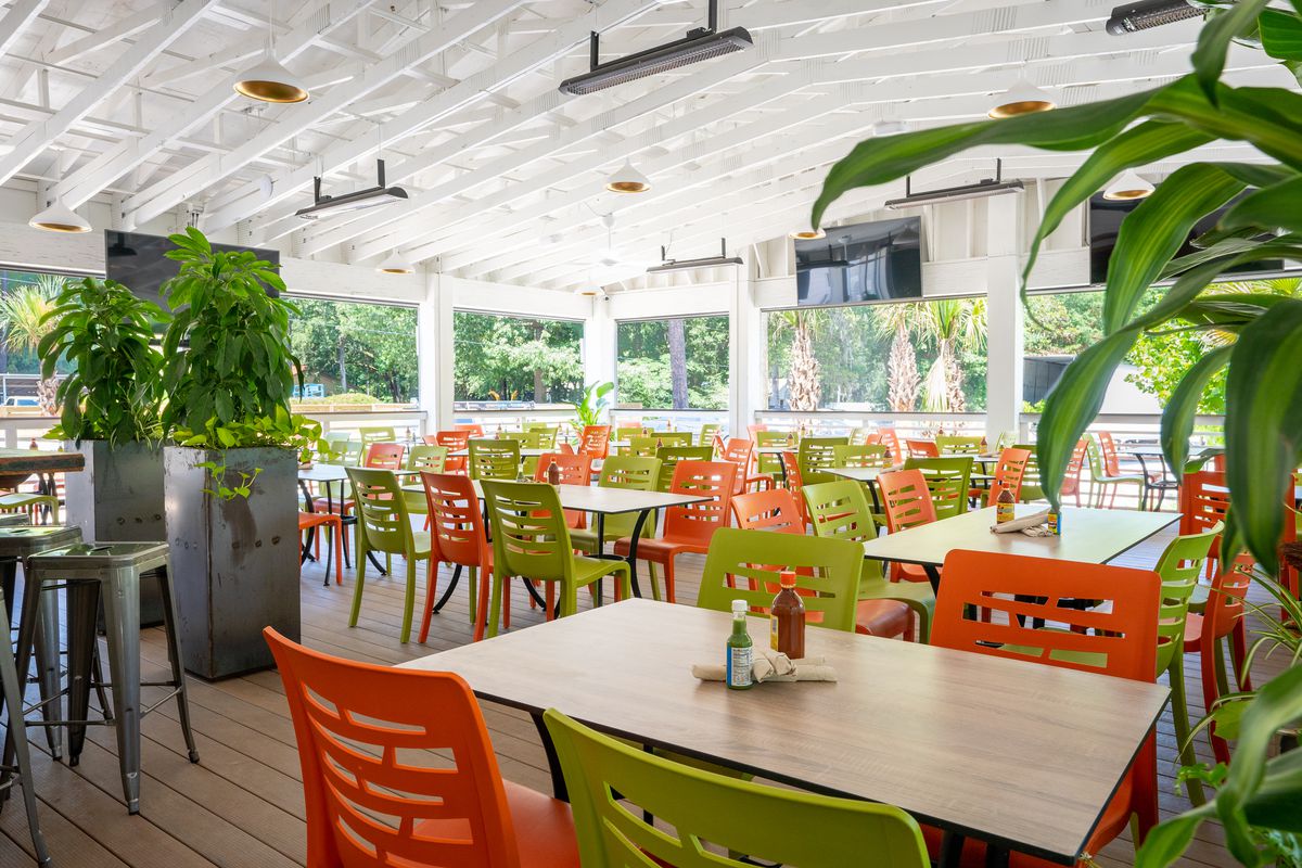A patio with bright orange and green chairs. 