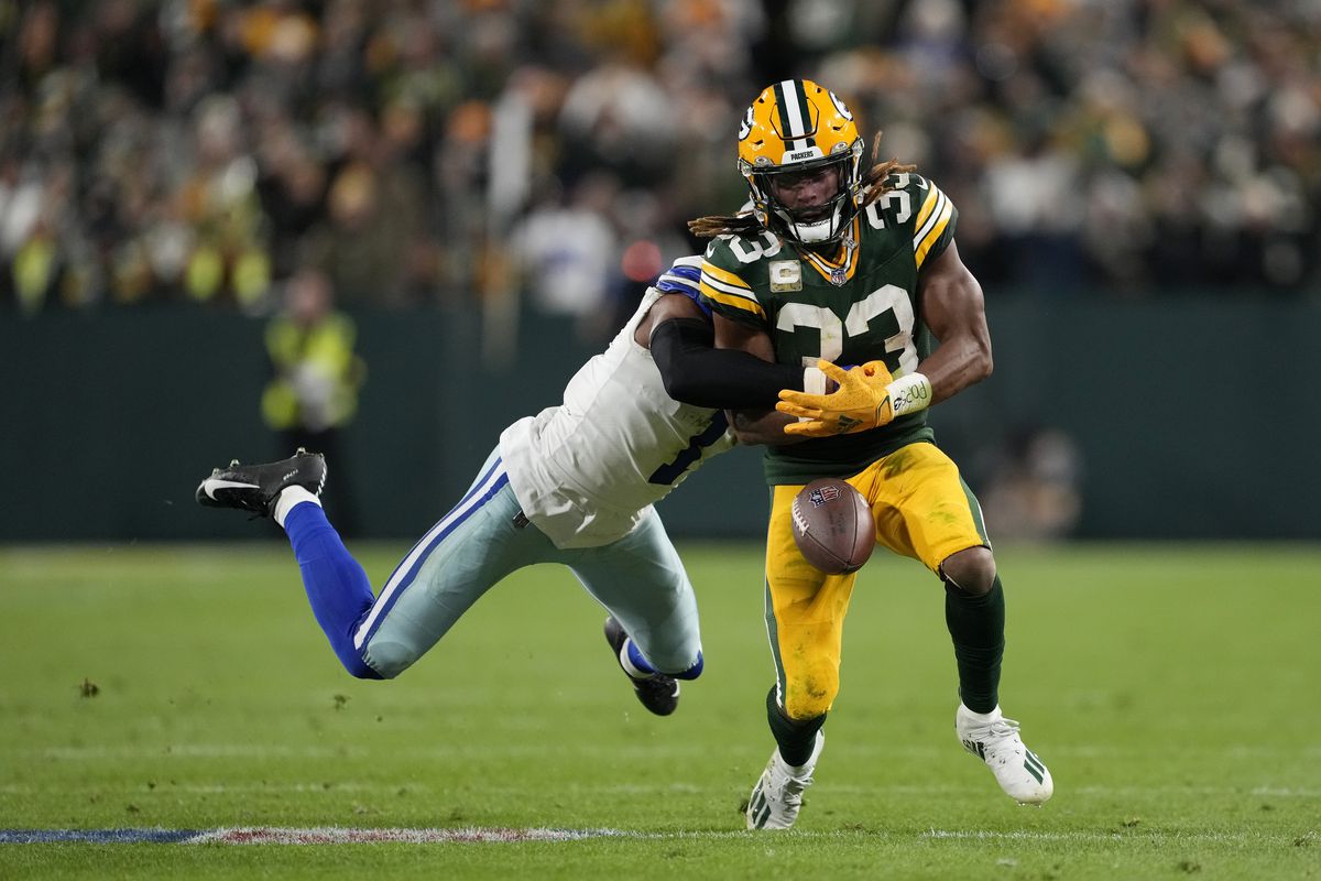 Aaron Jones #33 of the Green Bay Packers fumbles the ball as he is tackled by Kelvin Joseph #1 of the Dallas Cowboys in the second half at Lambeau Field on November 13, 2022 in Green Bay, Wisconsin.