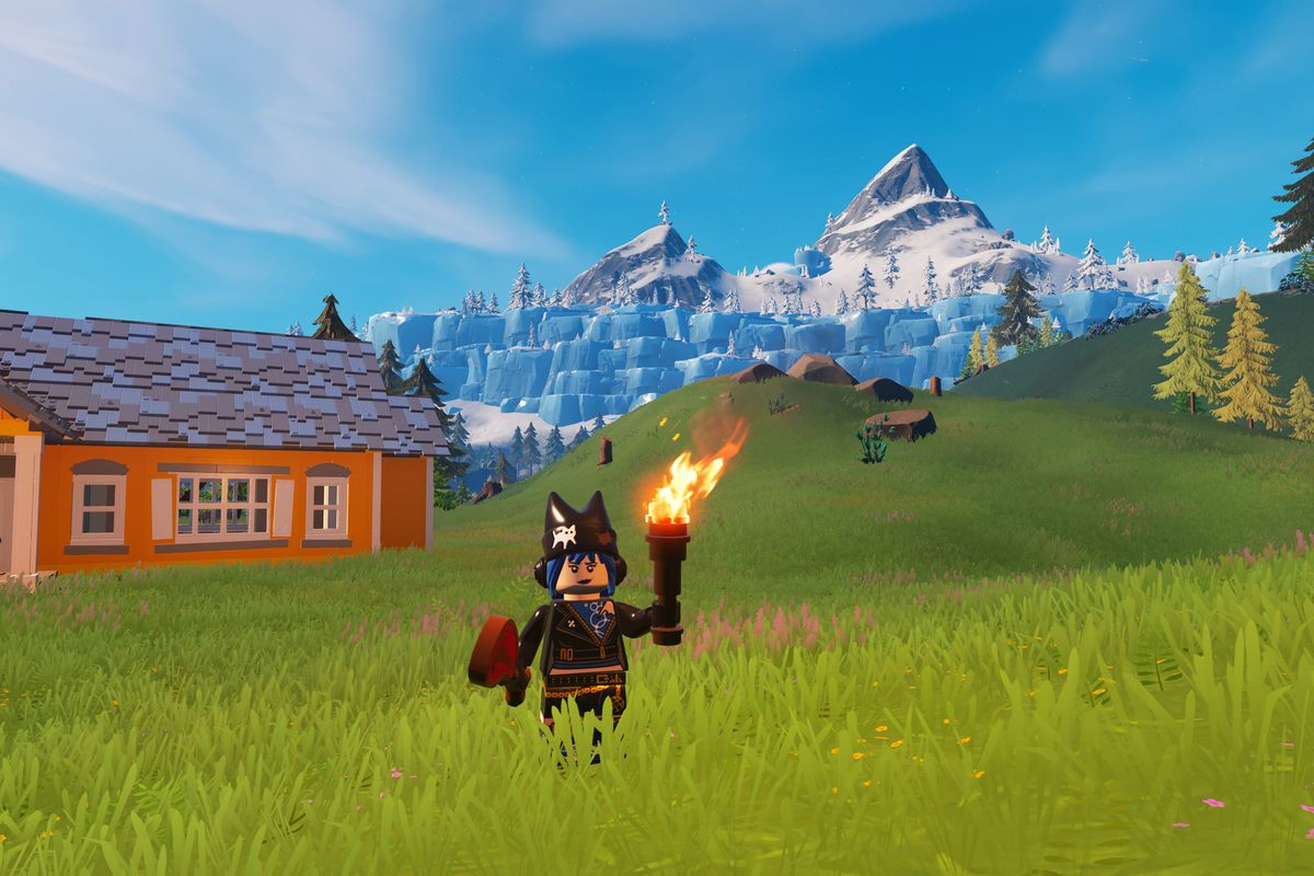 A Lego Fortnite NPC stands in a grass field with a snowy biome behind her