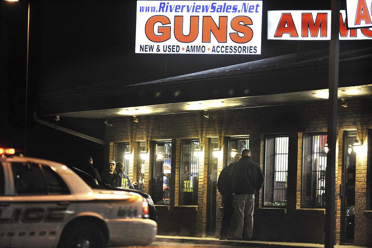 In this Dec. 20, 2012 photo, law enforcement officials stand outside Riverview Gun Sales, as authorities raid the store in East Windsor, Conn.  The shop, which sold a gun to Nancy Lanza, mother of Newtown school shooter Adam Lanza, had its federal firearm