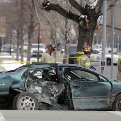 Emergency responders work at the scene of an accident after a driver hit a tree and a building at a high rate of speed near 900 South and West Temple in Salt Lake City on Thursday, March 14, 2019.