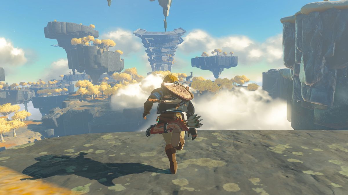 Link runs toward the edge of a rocky platform, with floating rock formations in the background, in a screenshot from The Legend of Zelda: Tears of the Kingdom