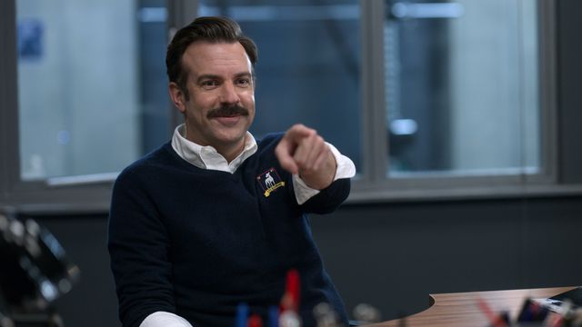 Jason Sudeikis grins and points into the camera in Ted Lasso
