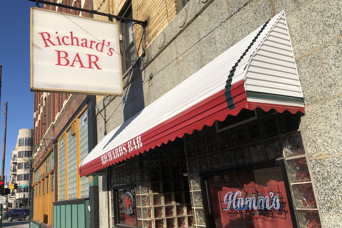 A red and white awning outside a dive bar with a sign that reads “Richard’s Bar.”