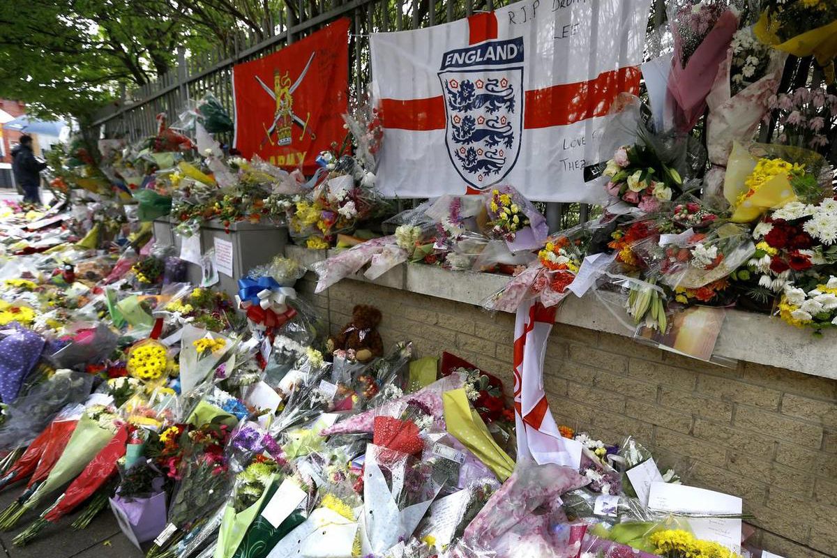 Some of the thousands of floral and other tributes left at the scene near Woolwich Barracks in London, Tuesday, May 28, 2013, where 25-year-old soldier of the Royal Regiment of Fusiliers Lee Rigby was attacked and killed last week. Two men attacked and ki