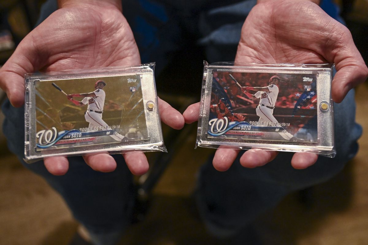 Bryce Onaran, 47, at his home with his sports cards collection, holds two, 2018 Topps Juan Soto rookie debut cards on May 3, 2022 in Washington, D.C. Onaran has a 2018 Washington Nationals Juan Soto (1 of 10) rookie cards that will be auctioned off this May. The card, which is in the possession of the auction house, could fetch tens of thousands of dollars.