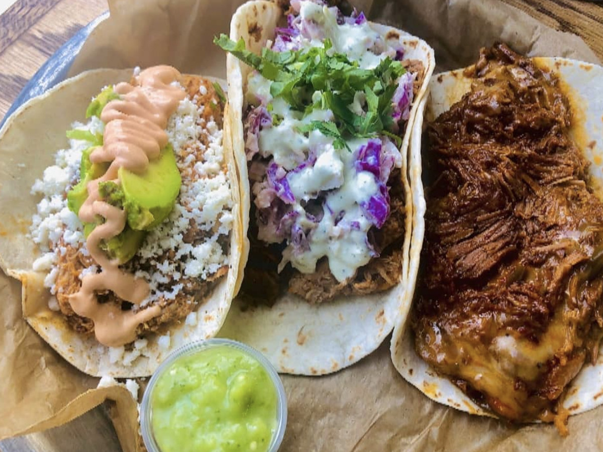 Three tacos with various fillings. 