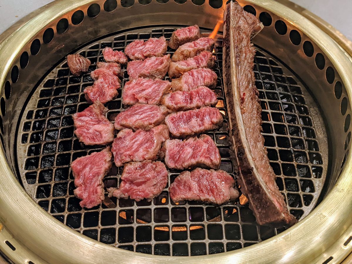 Grilled beef short rib from AB Steak over an open grate grill and bone.