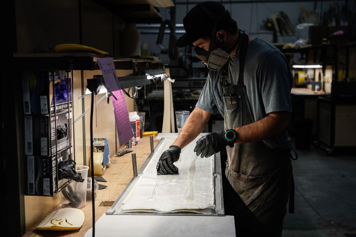 Dane Weister, product specialist at WNDR Alpine, a local company that uses algae-based bioplastics to replace plastics used in ski construction, glues the layers of a ski together at the company's facility in Salt Lake City on Friday November 19, 2021.
