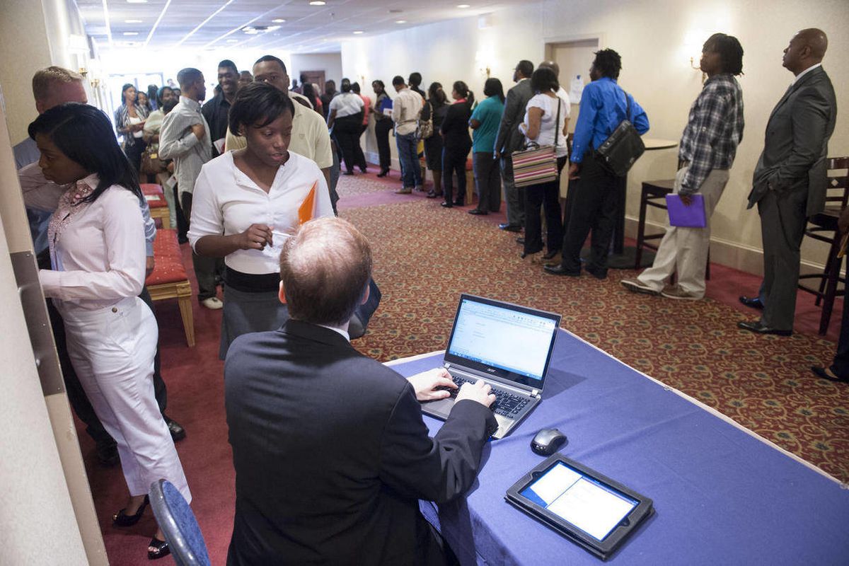 In this May 30, 2013, file photo, job seekers line up to register to attend a job fair in Atlanta. 