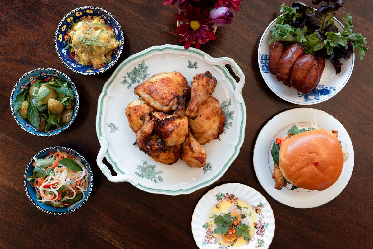 A collection of seven dishes filled with food on a wooden table.