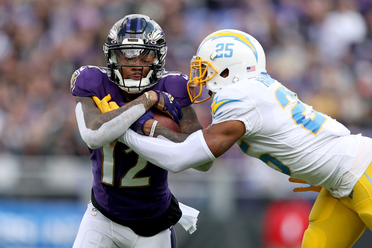 Chris Harris Jr. #25 of the Los Angeles Chargers tackles Rashod Bateman #12 of the Baltimore Ravens during the third quarter at M&amp;T Bank Stadium on October 17, 2021 in Baltimore, Maryland.