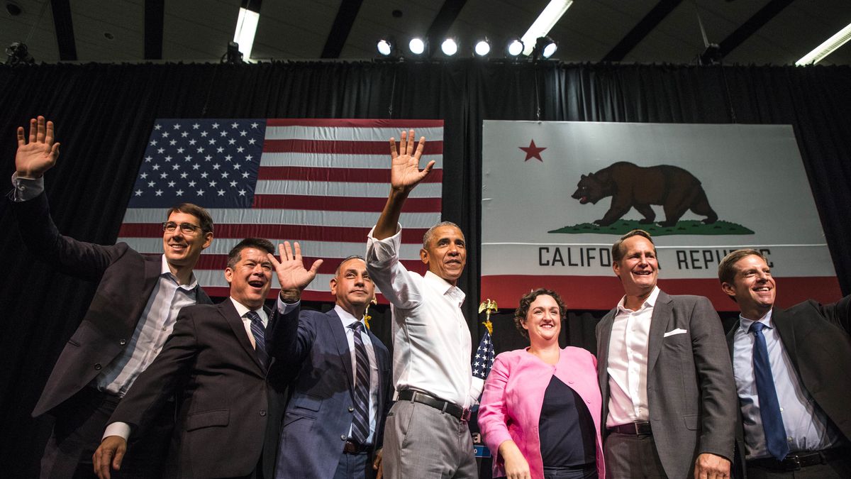 Josh Harder, at furthest left, in a group photo with former President Barack Obama standing in front of an American flag and a California state flag