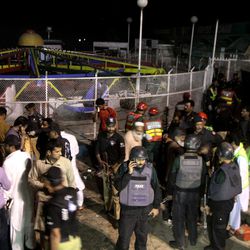 Pakistani police officers and rescue workers gather at the site of bomb explosion in a park in Lahore, Pakistan, Sunday, March, 27, 2016. A bomb blast in a park in the eastern Pakistani city of Lahore has killed tens of people and wounded scores, a health official said. 