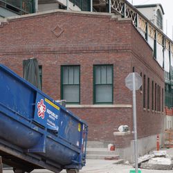 Dumpster being delivered, in front of the renovated groundskeeper's cottage