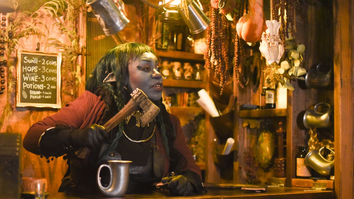 A person in a woodland creature costume behind a bar. 