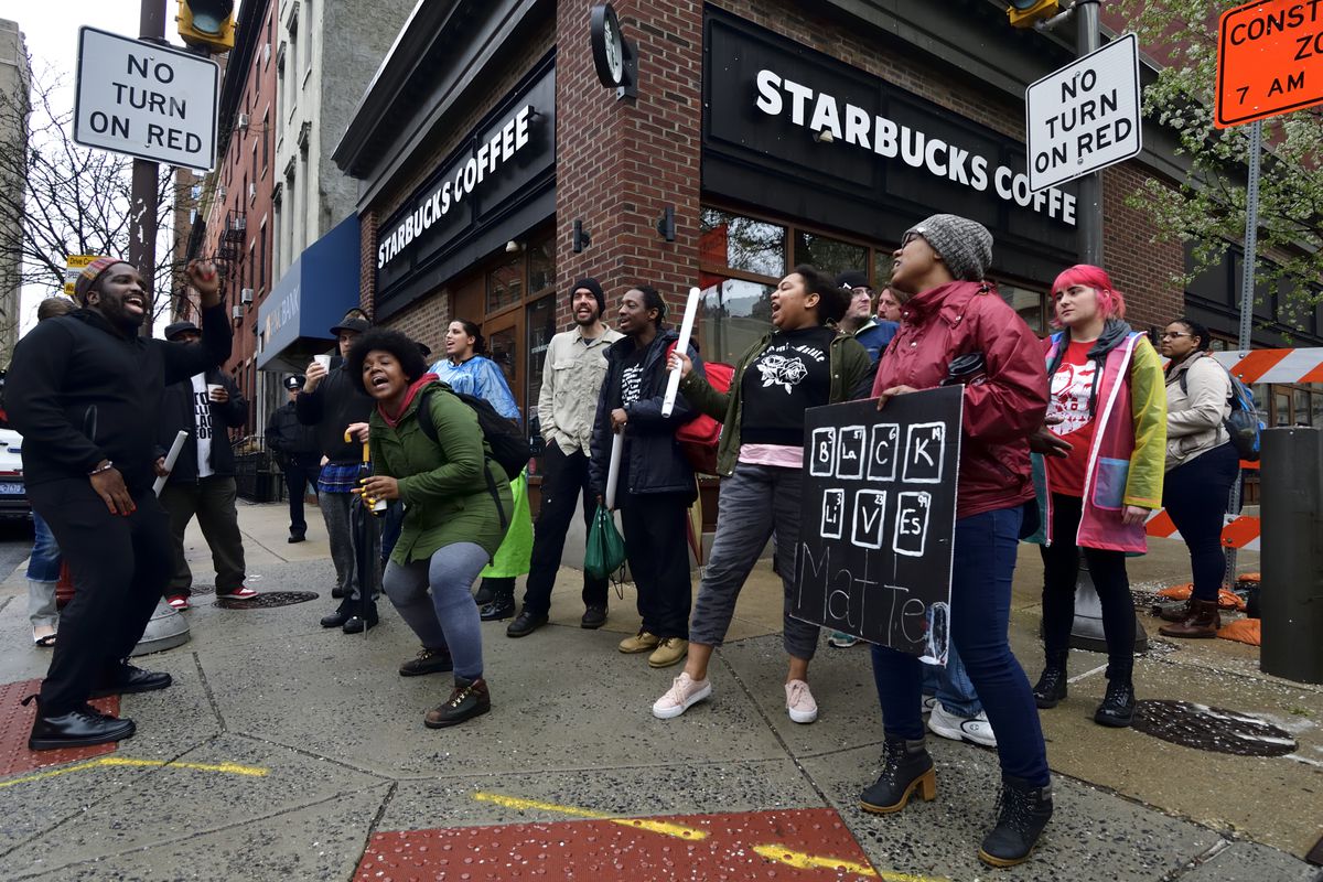 Protesters march past the Starbucks in Philadelphia’s Center City, where two black men were arrested for loitering