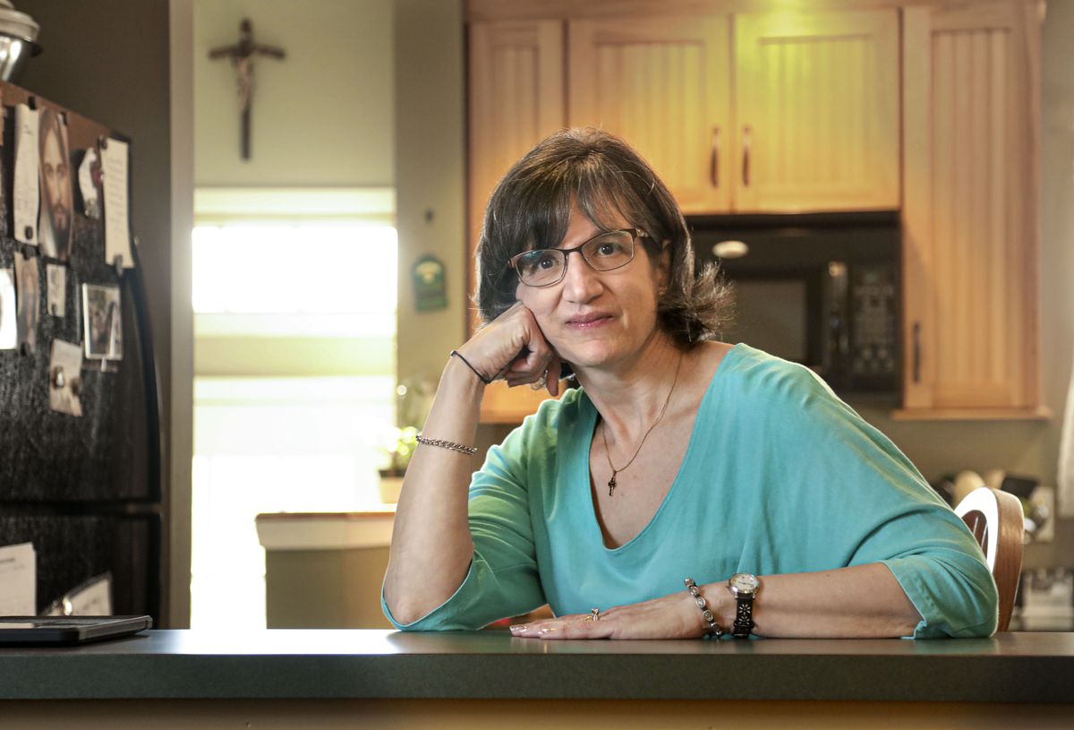 A woman sits at her kitchen counter.