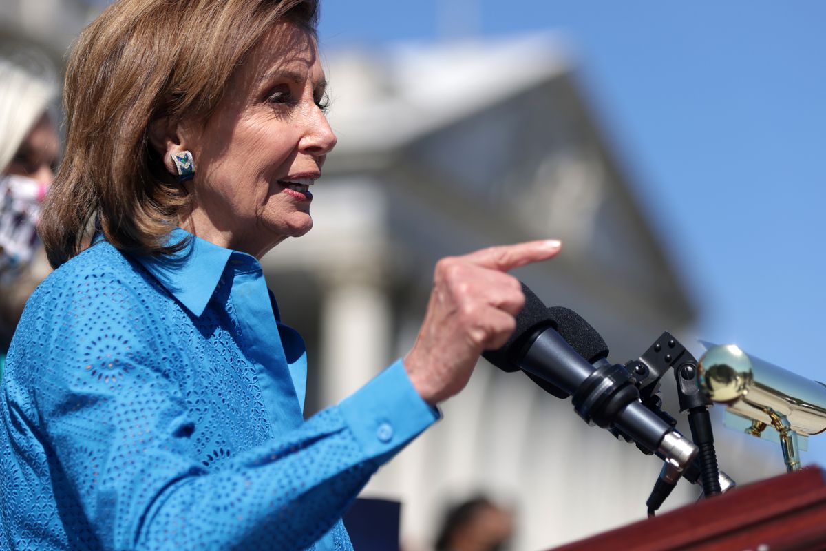 Speaker Nancy Pelosi gestures from behind a podium while speaking outside of the US Capitol.