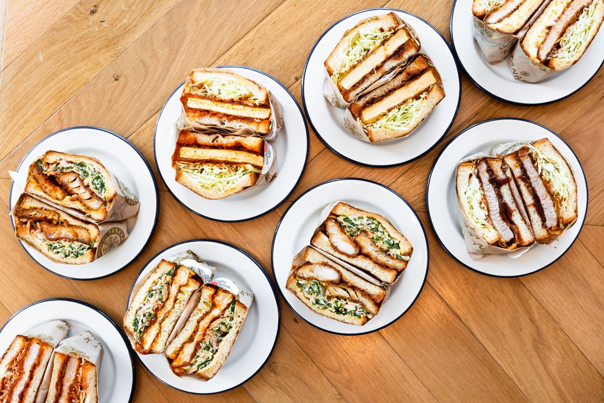A variety of halved sandwiches on plates.