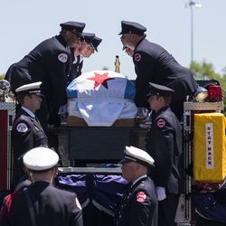 Firefighters lift Juan Bucio’s casket off a fire truck for his funeral at St. Rita of Cascia High School. | Ashlee Rezin/Sun-Times