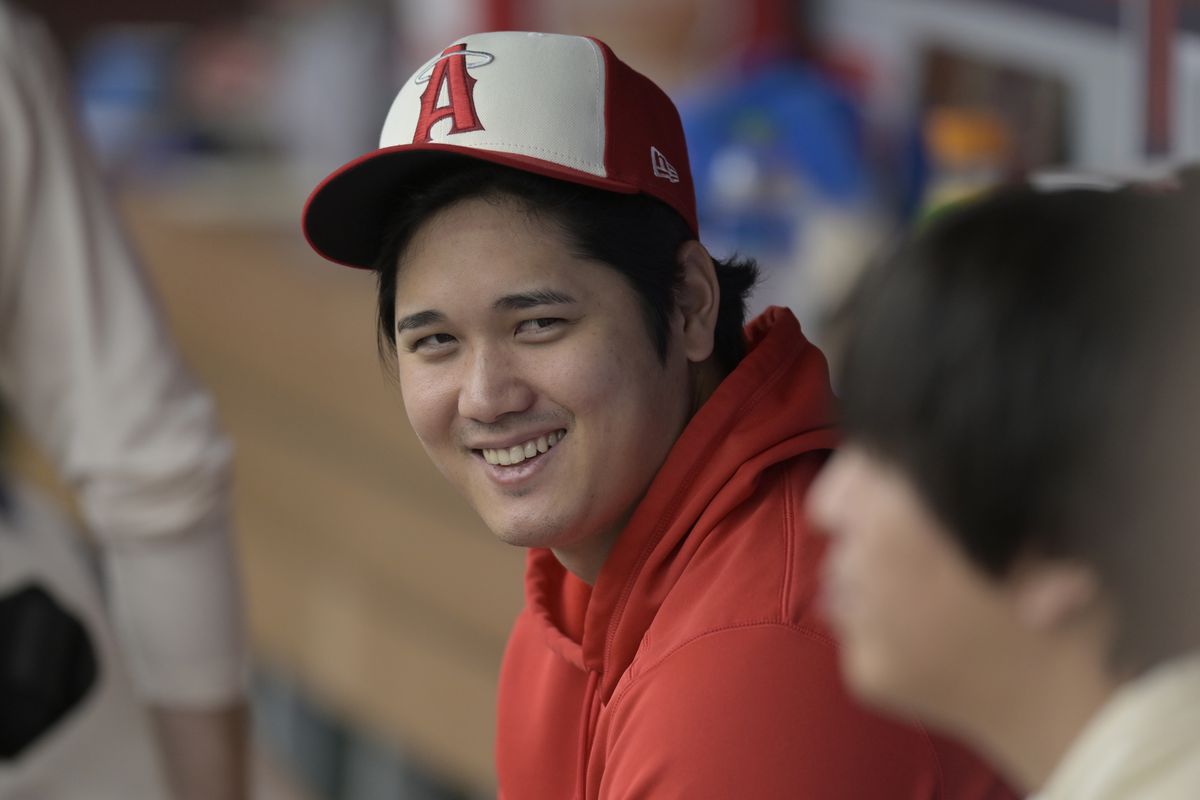Shohei Ohtani smiling in the dugout. 
