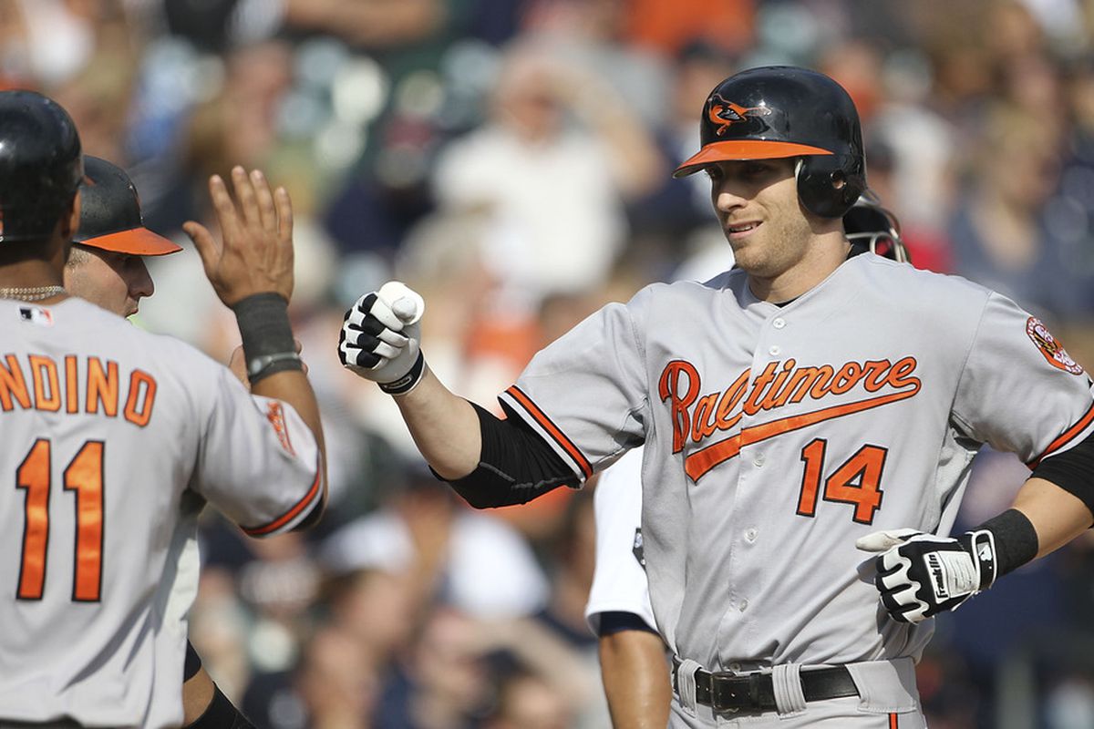 Nolan Reimold #14 of the Baltimore Orioles is congradulated by Robert Andino #11 after hitting a three run home run in the eighth ining during the game against the Detroit Tigers at Comerica Park on September 25, 2011 in Detroit, Michigan. 
