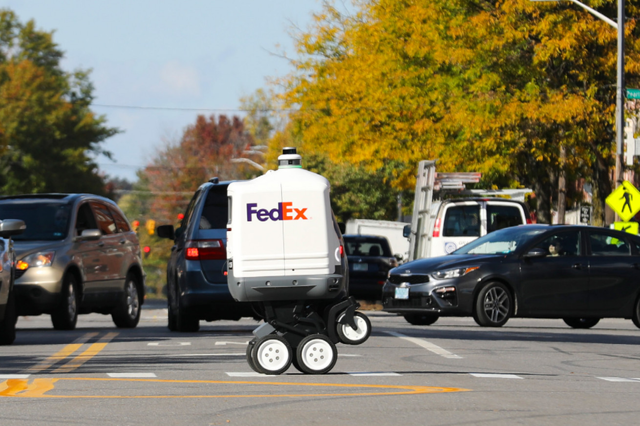 An image of a white wheeled robot crossing the road. 